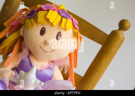 Child's fairy doll sitting on small wooden chair Stock Photo
