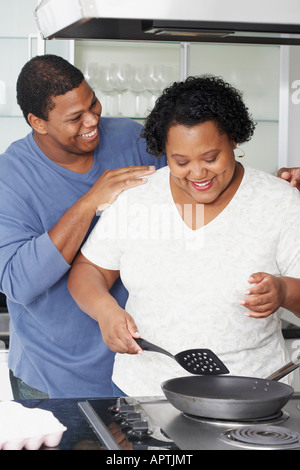 Happy african american couple cooking dinner together in kitchen Stock ...