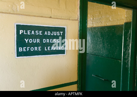 sign saying please adjust your dress before leaving in toilet on Corfe Castle station Purbeck Dorset UK Stock Photo