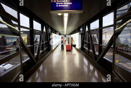 Passengers walk down toward the departure gate of Terminal 3 at Manchester International Airport in Manchester UK