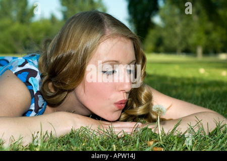Cute girl blowing seeds from a dandelion Stock Photo