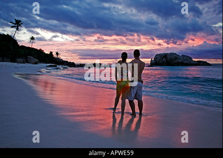 People on beach at sunset Model released Seychelles Cousine Island Stock Photo