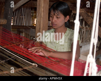 woman working a loom making silk from lotus threads at Inle Lake in Myanmar Stock Photo