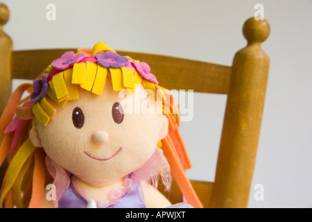 Child's fairy doll sitting on small wooden chair Stock Photo