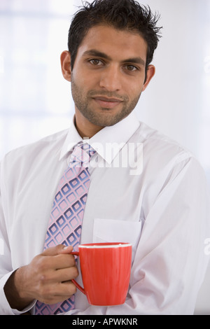 Indian businessman holding coffee mug Stock Photo