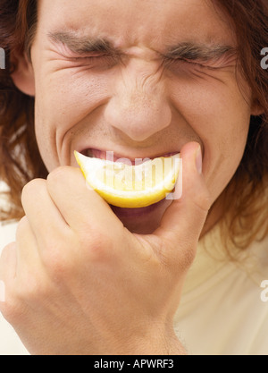 Man biting a slice of lemon Stock Photo
