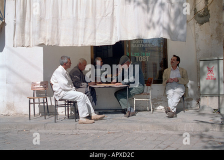 Men sitting about playing dominoes at cafe in local village in Southwestern Turkey Stock Photo