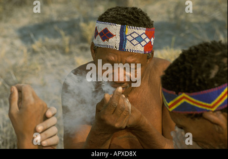 A portrait of a Bushman wearing a beaded headband and smoking a pipe Stock Photo