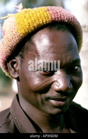 Portrait of a smiling Burkina Faso man with tribal scarring on his face and wearing a knitted hat Stock Photo