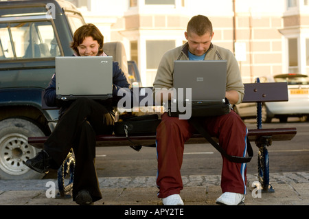 polish young people using laptops to access wireless network Aberystwyth promenade Stock Photo