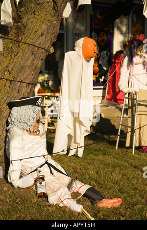 ILLINOIS Dixon Ghoulish Halloween decorations in front yard of house pumpkin head drunk pirate sitting by tree Stock Photo