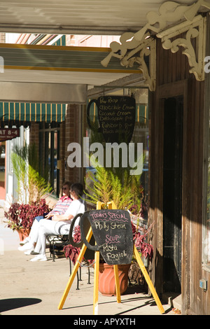 ILLINOIS Dixon Two women sit on bench outside Baker Street bakery and coffee shop downtown in small town Stock Photo