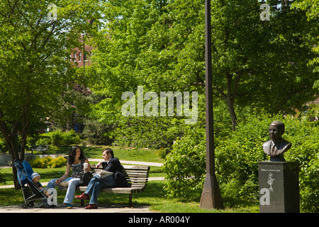 ILLINOIS Oak Park Couple sitting on park bench stroller nearby Scoville Park bust of Percy Julian Stock Photo