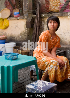 Burmese woman sitting at her empty food stall in Yangon Stock Photo