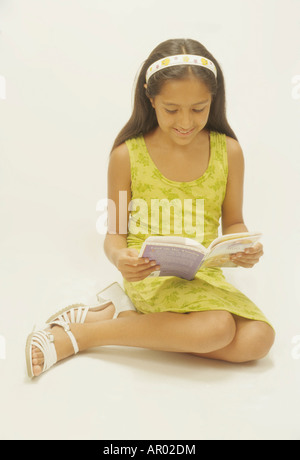 Young student reads book Hispanic female education homework school cut out Latino reading novel Stock Photo