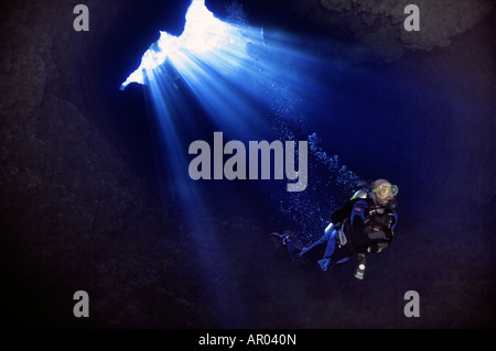 A scuba diver descends through Custom Cave in the Russell Islands, part of the Solomon Islands. Stock Photo