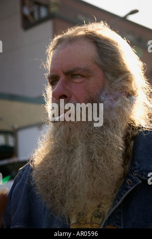 Middle aged man with long grey beard smoking cigarette No Release Available Stock Photo