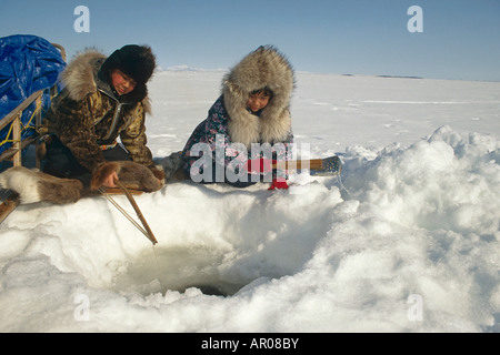 Natives Ice fishing in Kotzebue Western Alaska winter Stock Photo