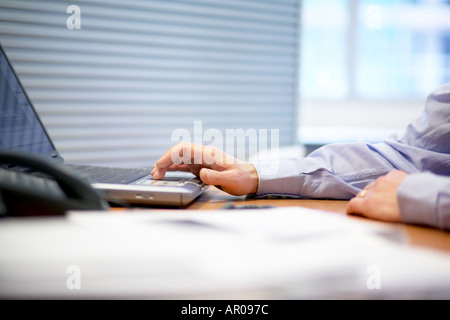 close up of mans hands typing on  laptop computer keyboard Stock Photo