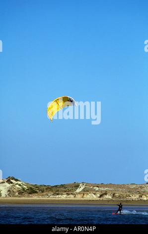 A lone kite surfer dashes across Alvor lagoon in the Algarve, southern Portugal Stock Photo