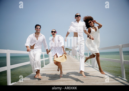 Young happy couples running on pier. Stock Photo