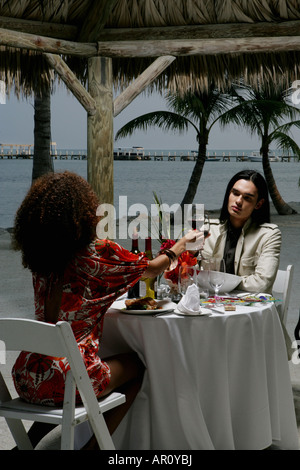 Young couple having romantic dinner at beach. Stock Photo