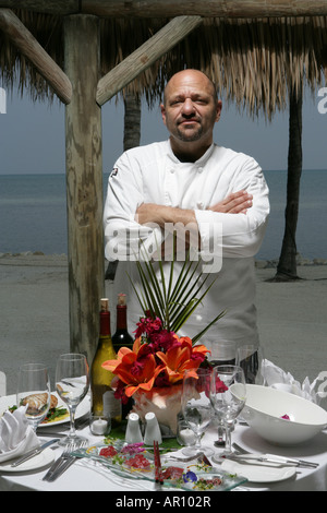 Chef standing in front of table at beach. Stock Photo