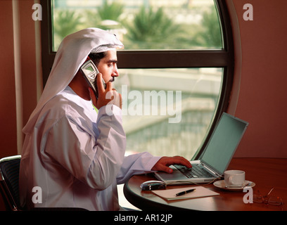 Arab Businessman talking on the phone in front of the computer Stock Photo