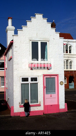 Fantasia a tiny little house in Aldeburgh Suffolk England with a toddler child trying to look in through the window Stock Photo