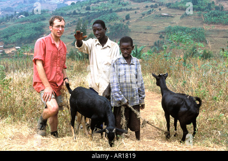 Rwanda Mark from UK Young Farmers helps genocide orphan Theogene with a gift of goats to child headed household  Stock Photo