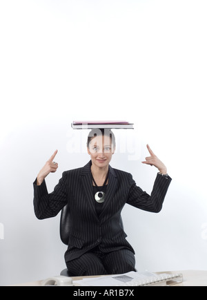 Young woman balancing book on head, portrait Stock Photo