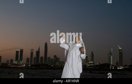 Young Arab man jumping with joy with Dubai City in the background Stock Photo