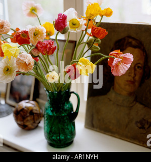 cut spring flowers in a green glass jug Stock Photo