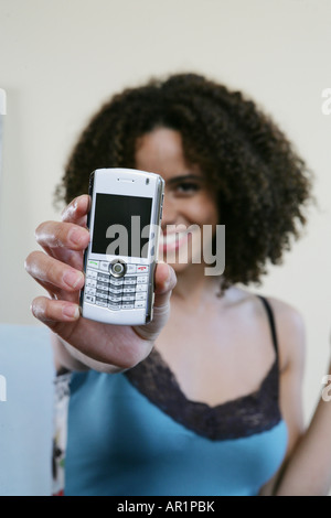 Woman holding a cellphone/blackberry up to camera Stock Photo