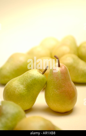still life image of a dozen Bartlett pears with two among many fruit leaning on each other Stock Photo