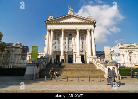 Horizontal wide angle of tourists on the steps of the front entrance of the Tate Britain Gallery on a bright sunny day. Stock Photo
