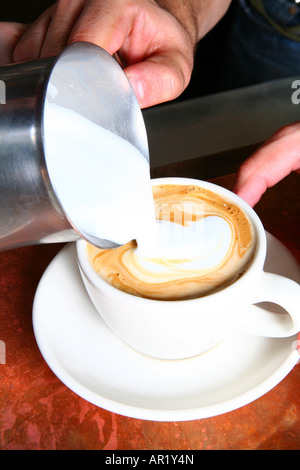 A barista making a latte Stock Photo