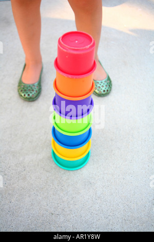 A child standing next to a stackable cups toy Stock Photo