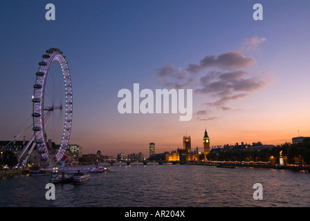 Horizontal wide angle of the river Thames at sunset with the London Eye 'Millennium Wheel' and Houses of Parliament illuminated. Stock Photo