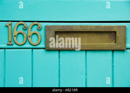 Close-up of brass letterbox in brightly coloured door of number 166 Stock Photo