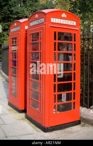Vertical full length view of two K6 model red telephone boxes on a London Street on a bright sunny day. Stock Photo