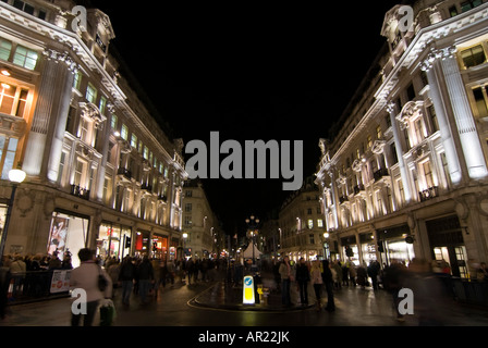 Horizontal wide angle of lots of Christmas shoppers walking in the street at Oxford Circus in central London at night Stock Photo