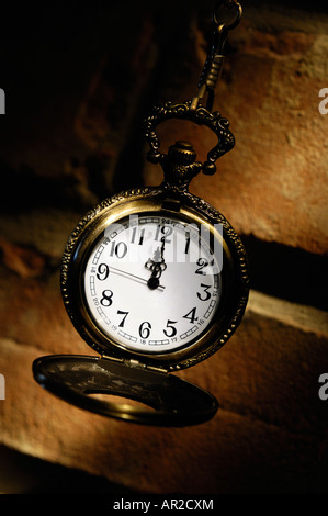 Antique brass pocket watch on a brick wall Stock Photo