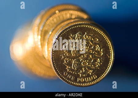 Stack of British pound coins on blue background Stock Photo