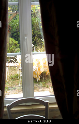 Garden table seen through window, curtains, Brittany, France, Europe Stock Photo