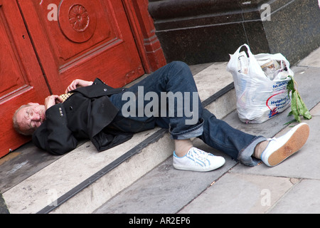 Homeless man sleeps in pub doorway London Stock Photo