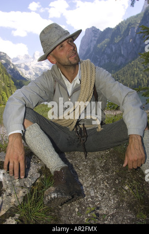 historic mountain climber with climbing rope having a rest, Austria, Gosautal, Alps Stock Photo