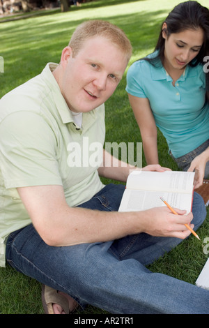 Two people together outside studying on lawn Stock Photo