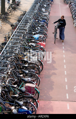 HOLLAND AMSTERDAM CYCLIST PARKING BIKE IN MULTI STOREY CYCLE PARK NEAR THE CENTRAL RAILWAY STATION Stock Photo