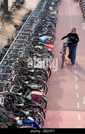 HOLLAND AMSTERDAM CYCLIST PARKING BIKE IN MULTI STOREY CYCLE PARK NEAR THE CENTRAL RAILWAY STATION Stock Photo